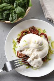 Photo of Delicious burrata cheese and sun-dried tomatoes on light grey table, top view