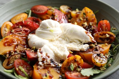 Fresh delicious burrata salad on table, closeup