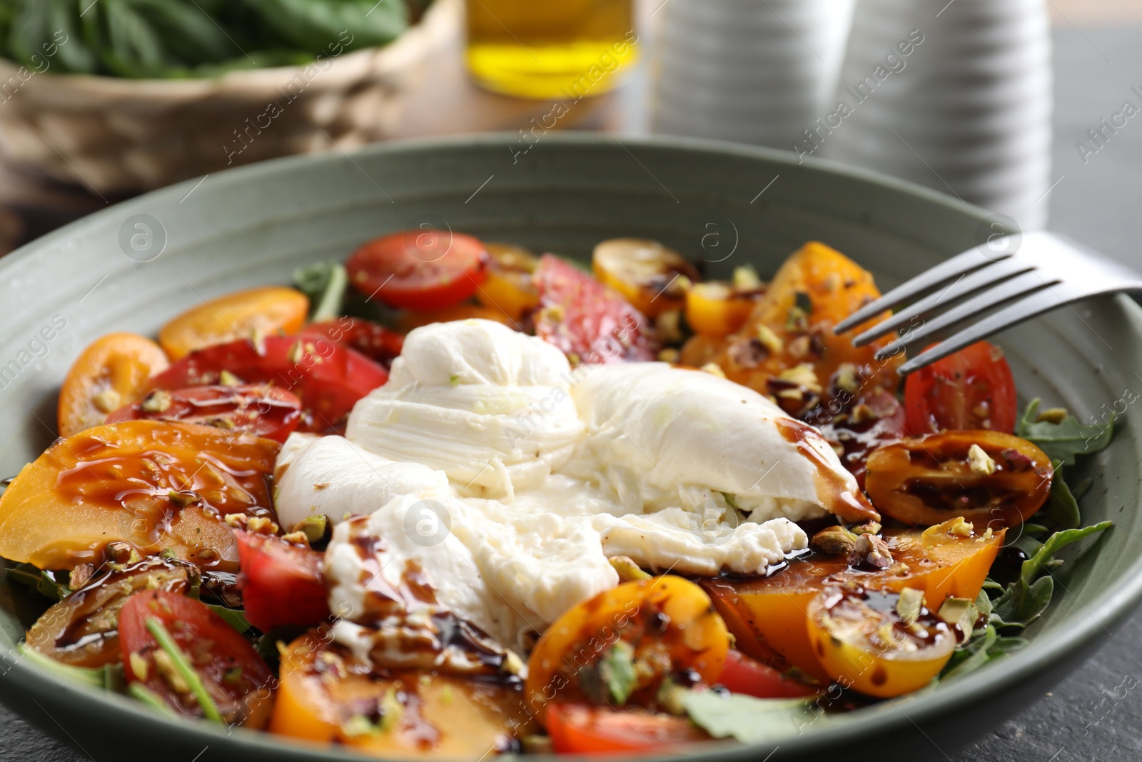 Photo of Fresh delicious burrata salad on table, closeup