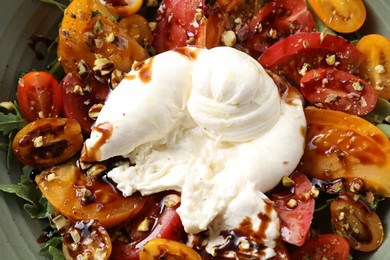 Fresh delicious burrata salad in bowl, top view