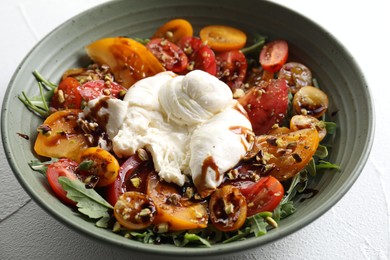 Fresh delicious burrata salad on white table, closeup