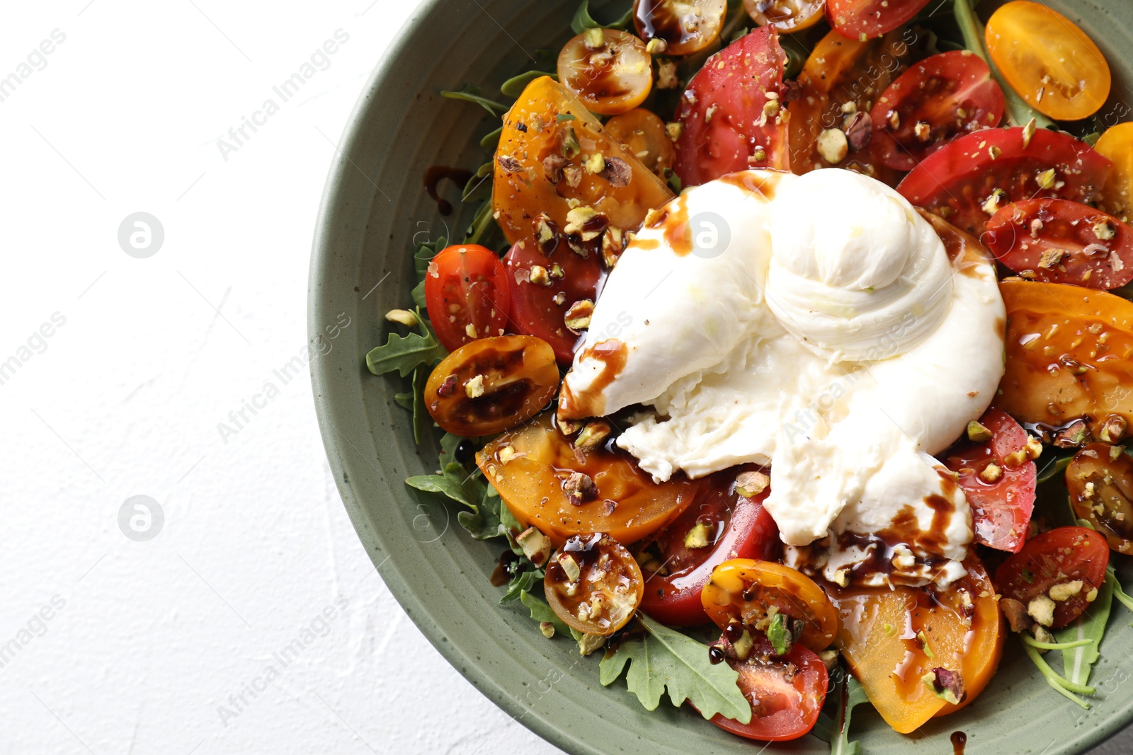 Photo of Fresh delicious burrata salad on white table, top view