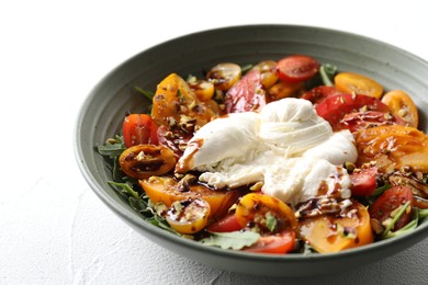 Photo of Fresh delicious burrata salad on white table, closeup