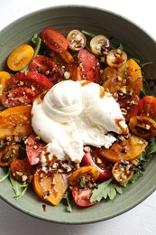 Photo of Fresh delicious burrata salad on white table, top view