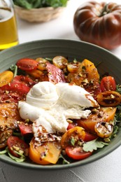 Photo of Fresh delicious burrata salad served on white table, closeup