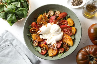 Photo of Fresh delicious burrata salad served on white table, top view