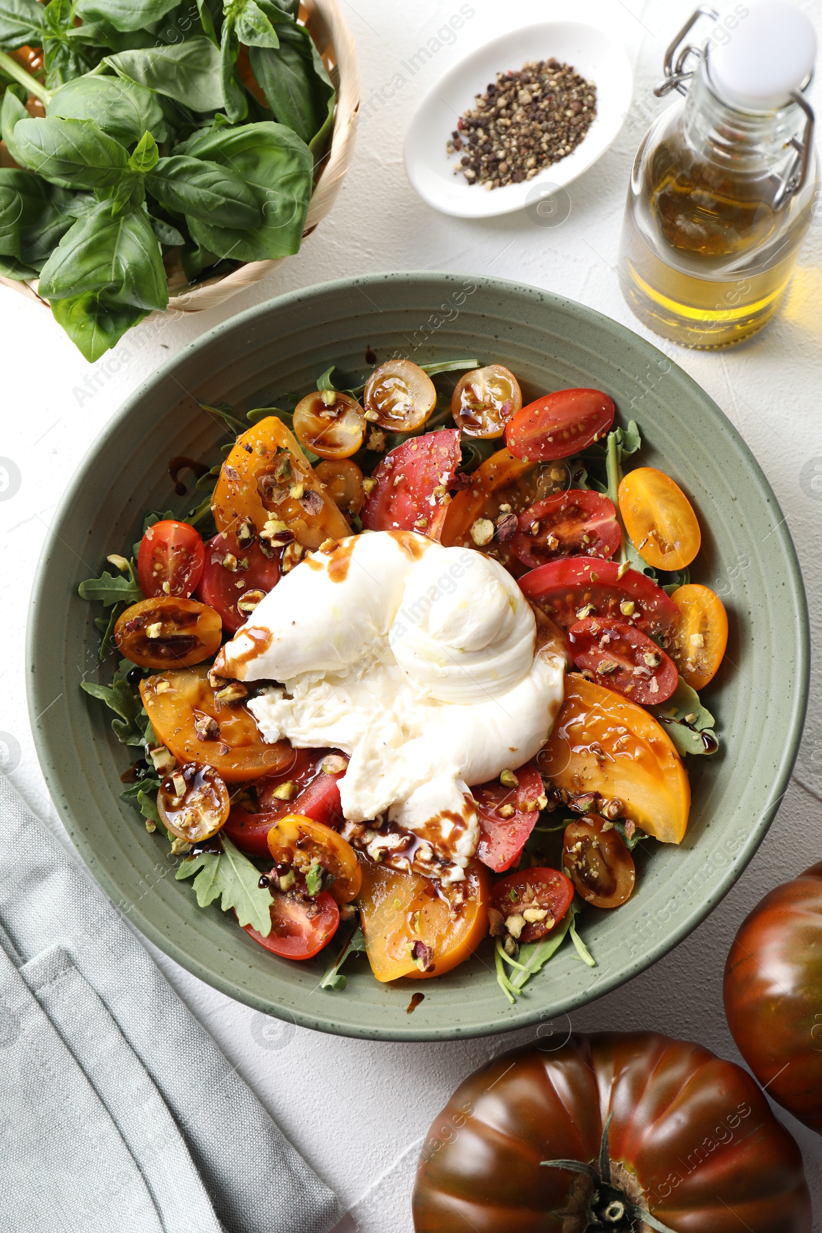 Photo of Fresh delicious burrata salad served on white table, top view