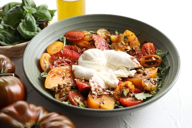 Photo of Fresh delicious burrata salad served on white table, closeup