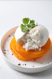 Photo of Delicious burrata cheese, tomato and parsley on white table, closeup