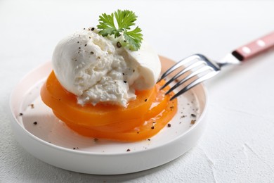 Photo of Delicious burrata cheese, tomato, parsley and fork on white table, closeup