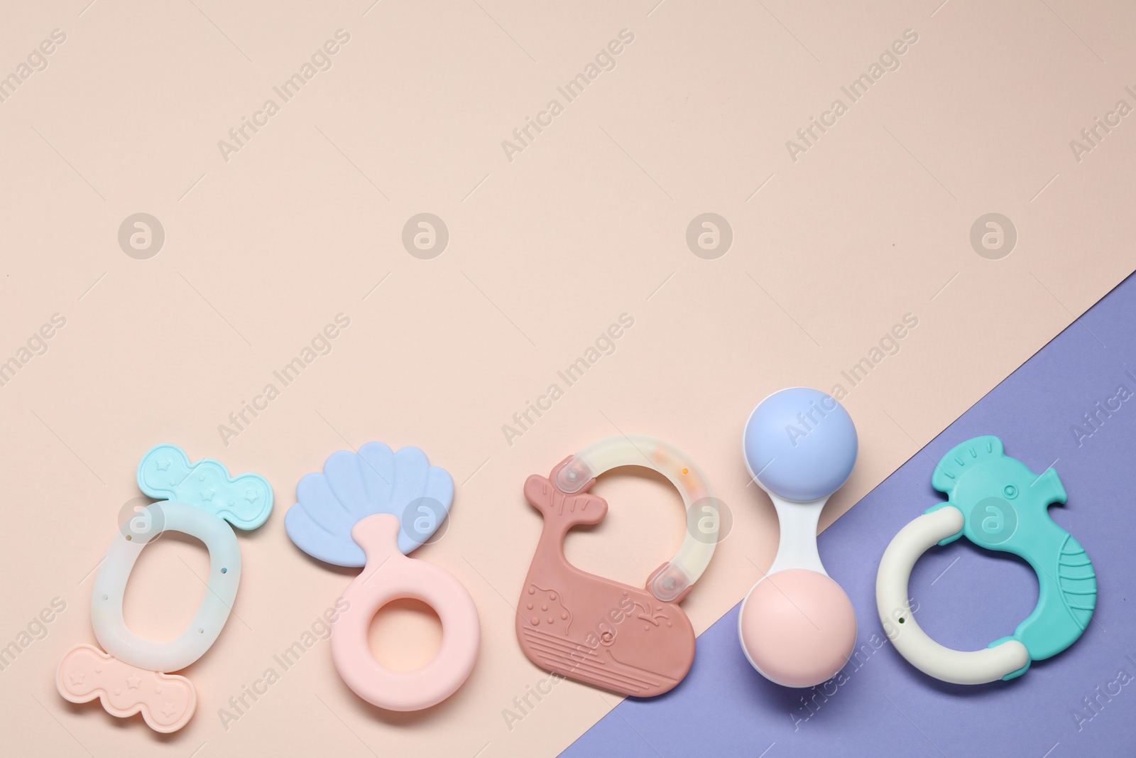 Photo of Bright rattles on color background, flat lay with space for text. Baby accessories