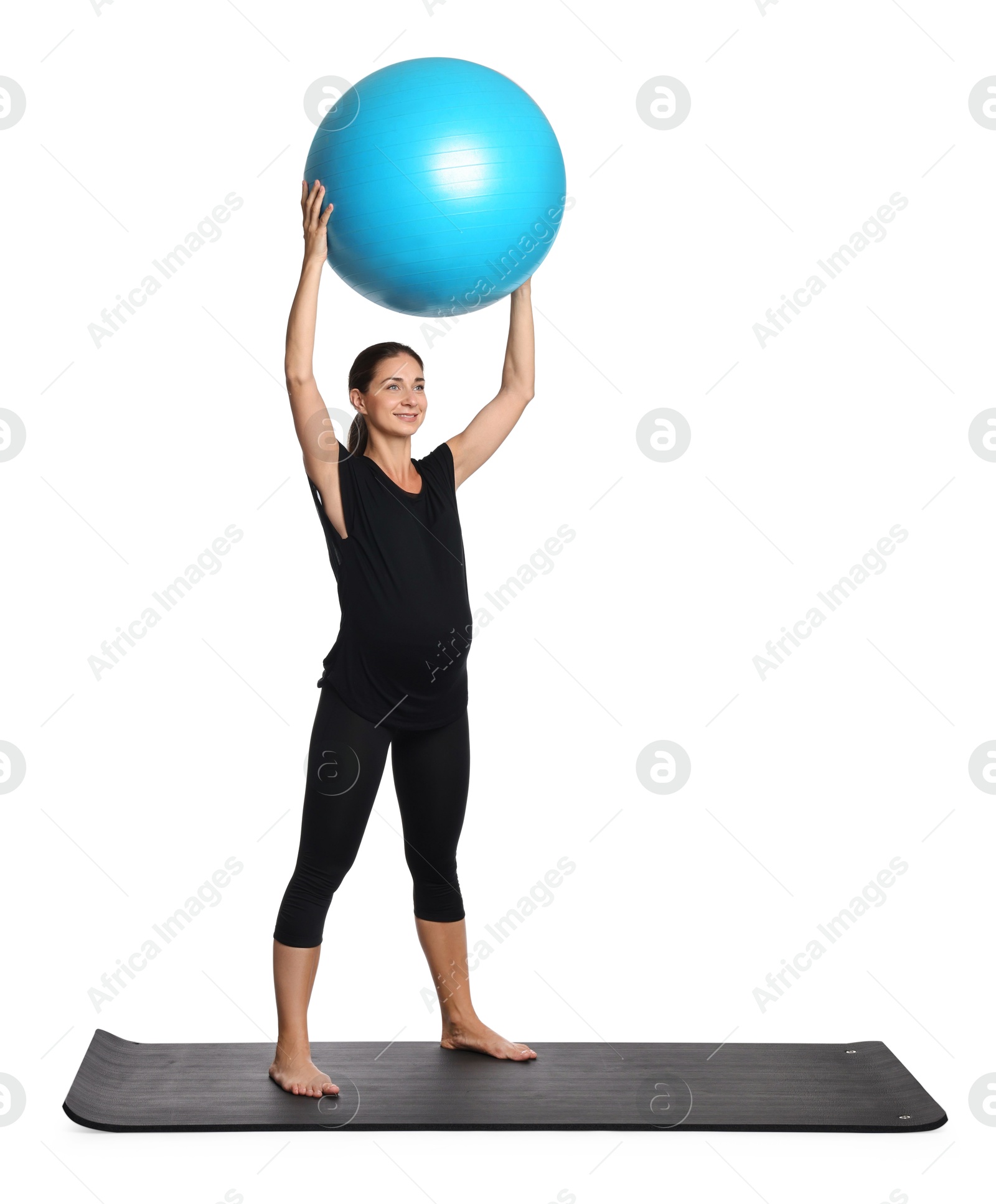 Photo of Beautiful pregnant woman with fitball doing exercises on mat against white background