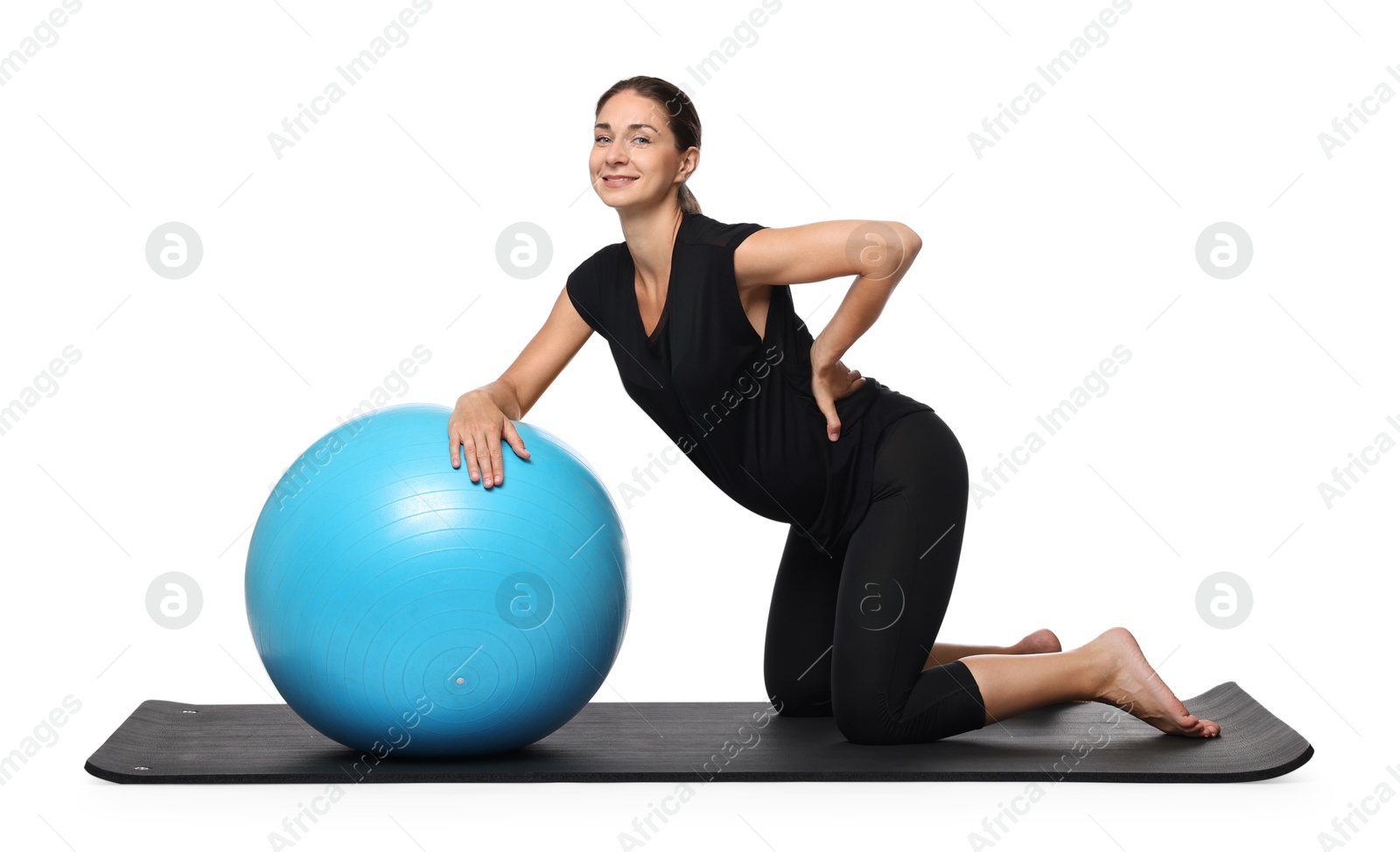 Photo of Beautiful pregnant woman with fitball doing exercises on mat against white background