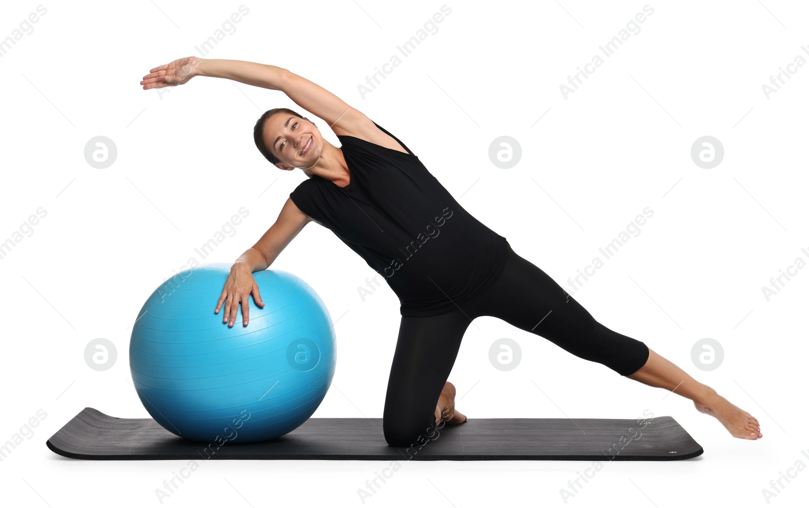 Photo of Beautiful pregnant woman with fitball doing exercises on mat against white background