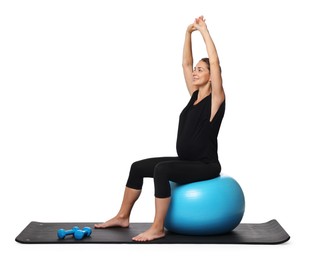 Beautiful pregnant woman doing exercises on fitball against white background