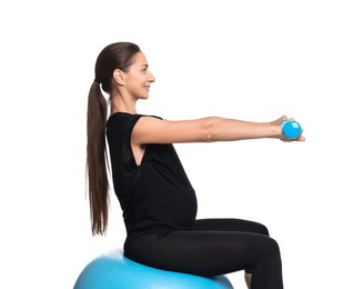 Beautiful pregnant woman with dumbbells doing exercises on fitball against white background