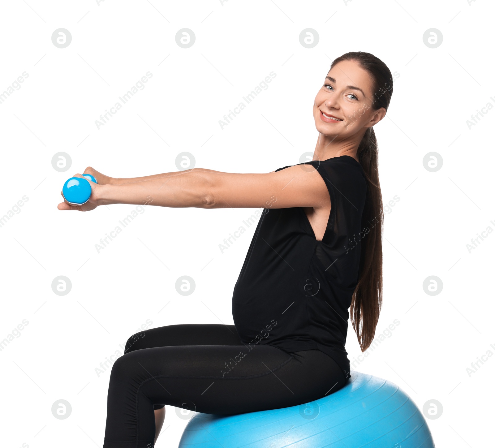 Photo of Beautiful pregnant woman with dumbbells doing exercises on fitball against white background