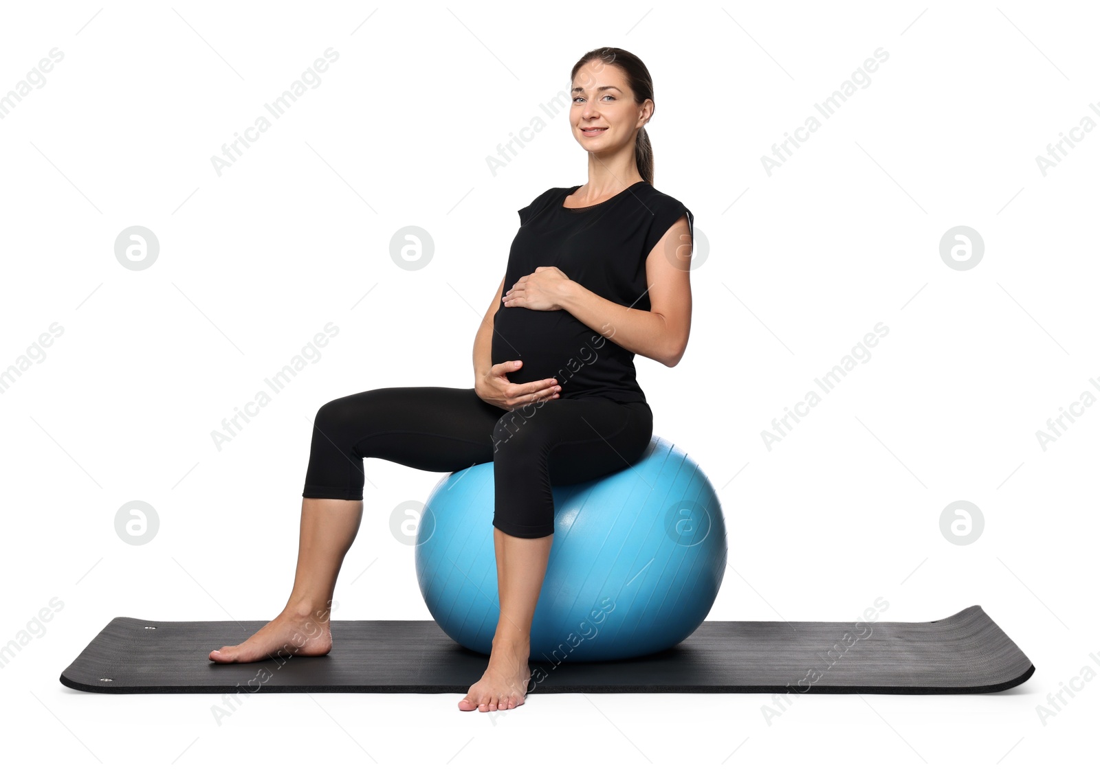 Photo of Beautiful pregnant woman doing exercises on fitball against white background