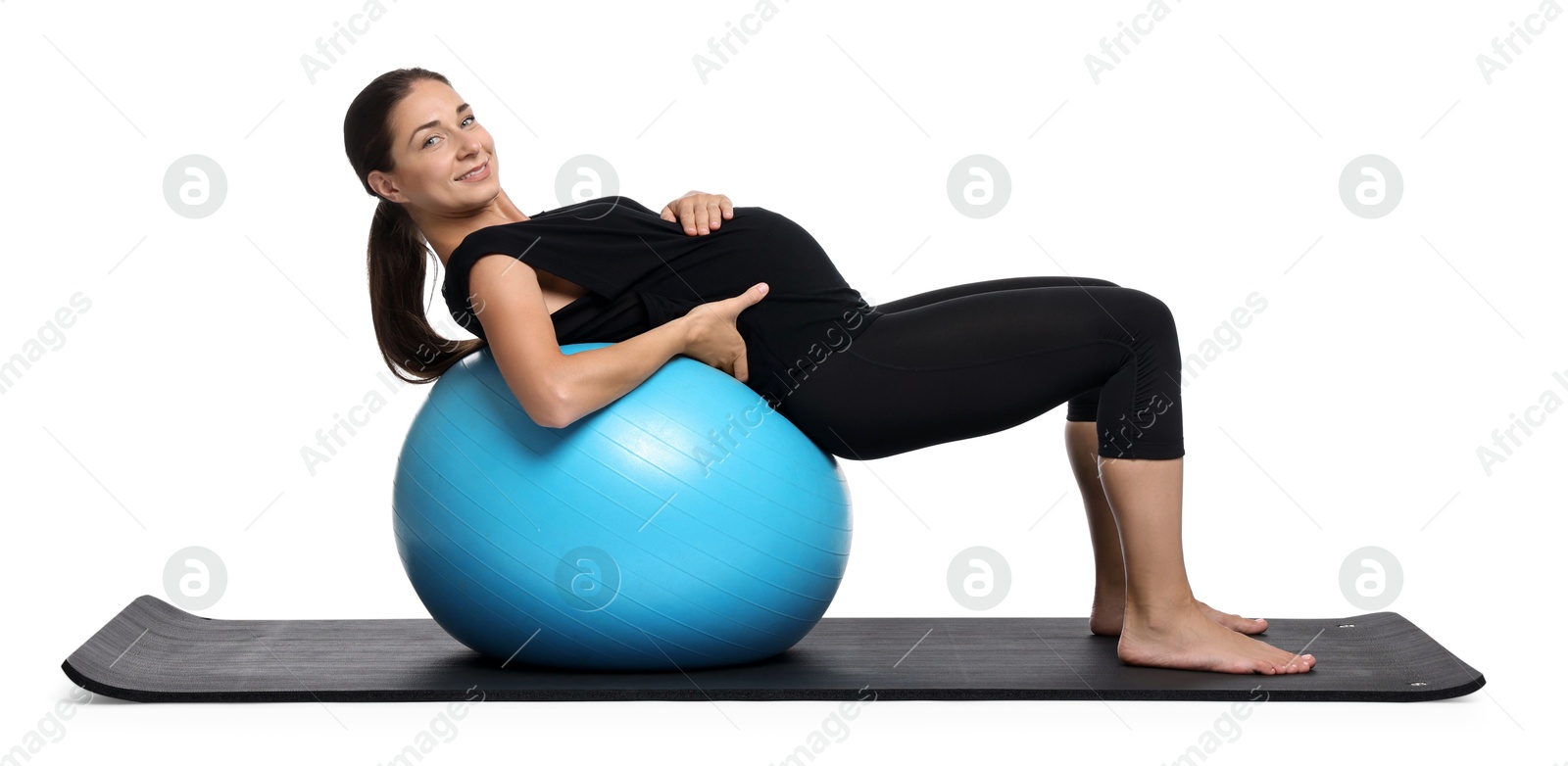 Photo of Beautiful pregnant woman doing exercises on fitball against white background