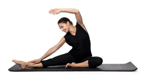 Beautiful pregnant woman doing stretching exercises on mat against white background