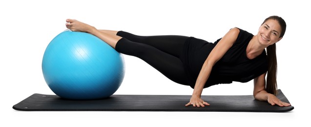 Photo of Beautiful pregnant woman with fitball doing exercises on mat against white background