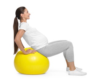 Beautiful pregnant woman doing exercises on fitball against white background