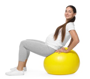 Beautiful pregnant woman doing exercises on fitball against white background