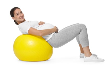 Beautiful pregnant woman doing exercises on fitball against white background