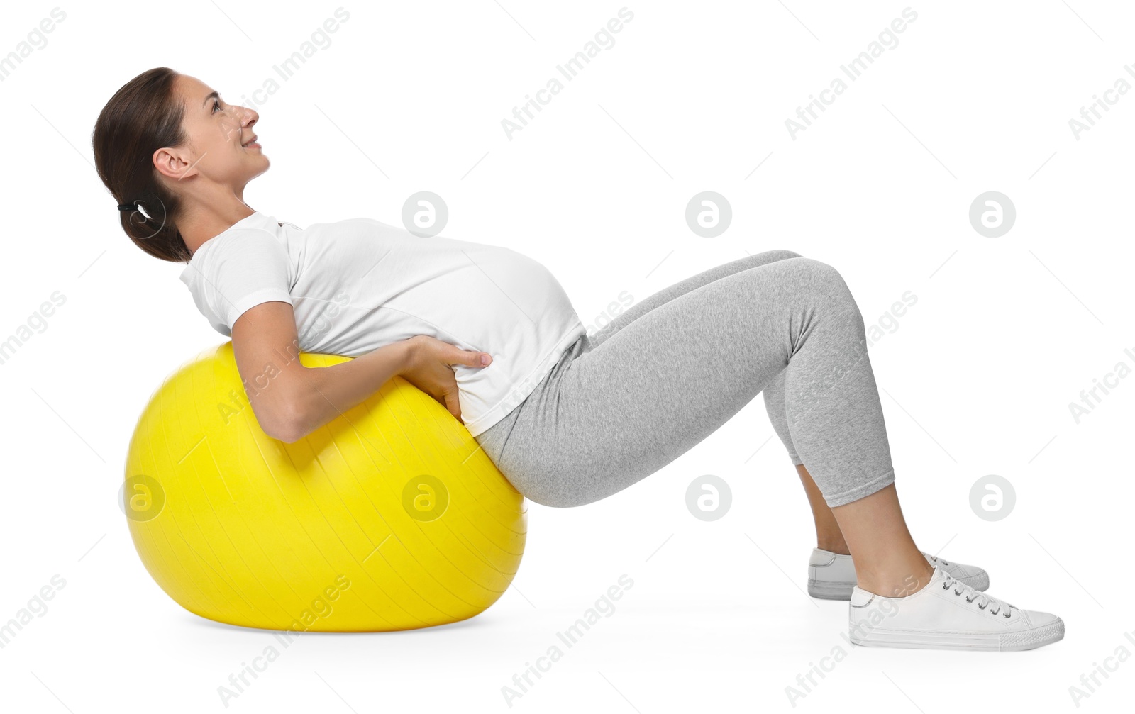 Photo of Beautiful pregnant woman doing exercises on fitball against white background