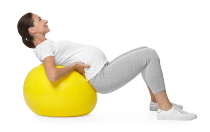 Beautiful pregnant woman doing exercises on fitball against white background