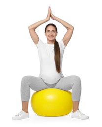 Photo of Beautiful pregnant woman doing exercises on fitball against white background