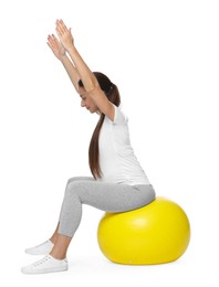 Photo of Beautiful pregnant woman doing exercises on fitball against white background