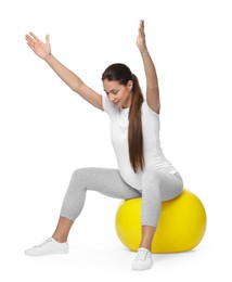 Beautiful pregnant woman doing exercises on fitball against white background