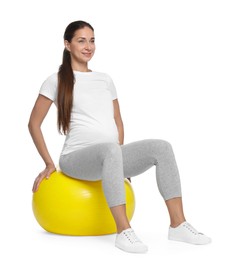 Photo of Beautiful pregnant woman doing exercises on fitball against white background