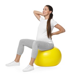 Beautiful pregnant woman doing exercises on fitball against white background