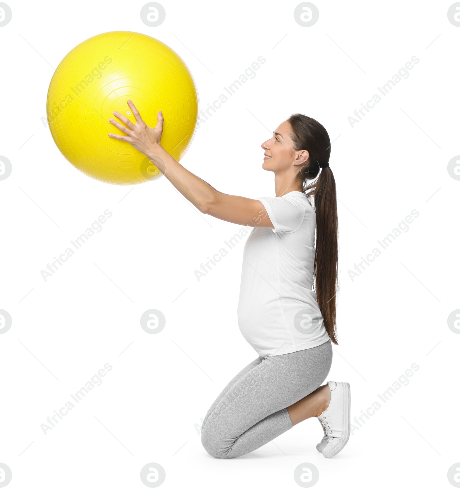 Photo of Beautiful pregnant woman with fitball doing exercises on white background