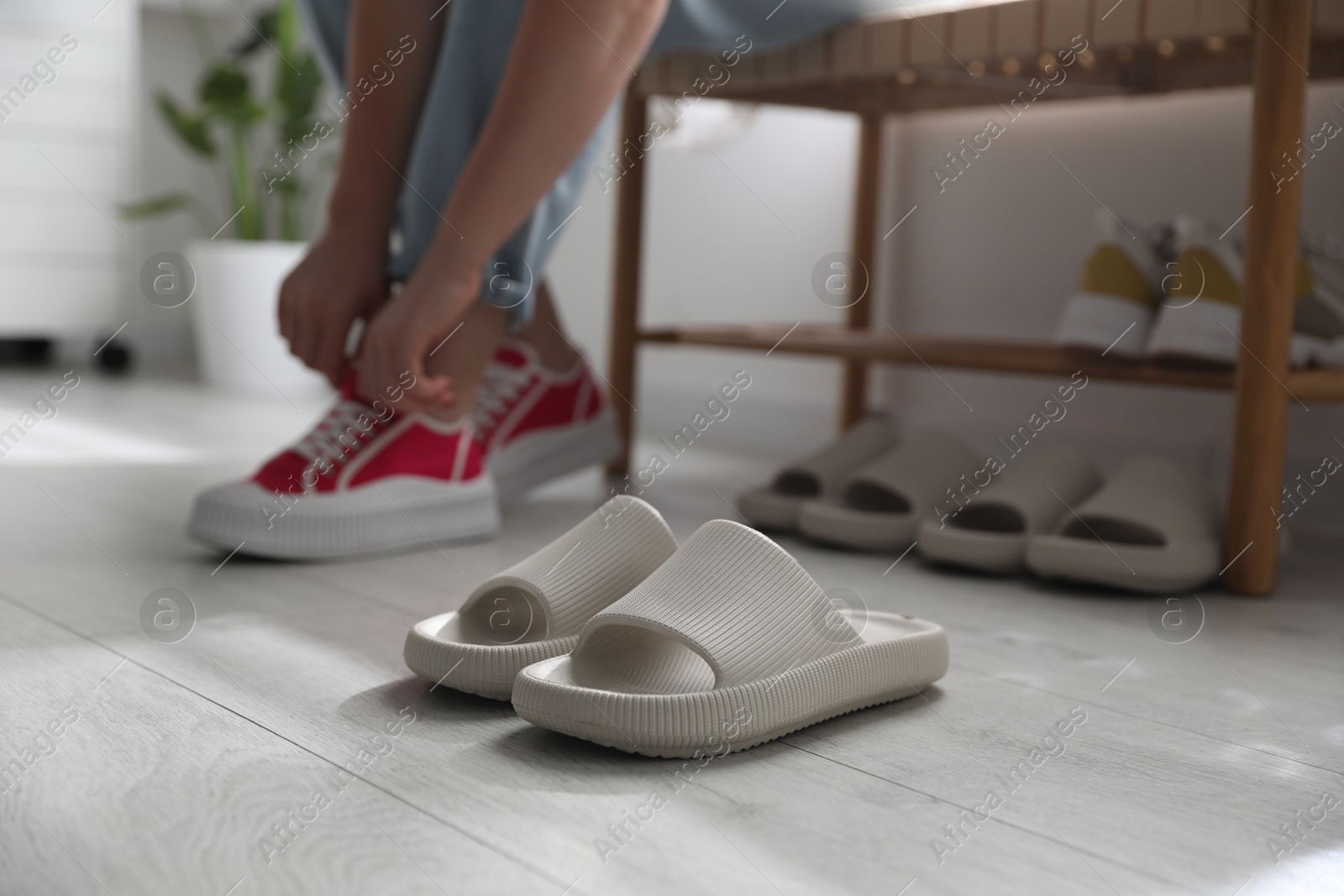 Photo of Woman changing into slippers at home, closeup