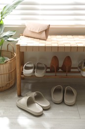 Many pairs of slippers and other shoes in entryway at home