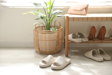 Photo of Many pairs of slippers and other shoes in entryway at home