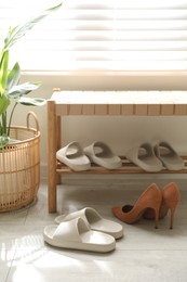 Photo of Many pairs of slippers and other shoes in entryway at home