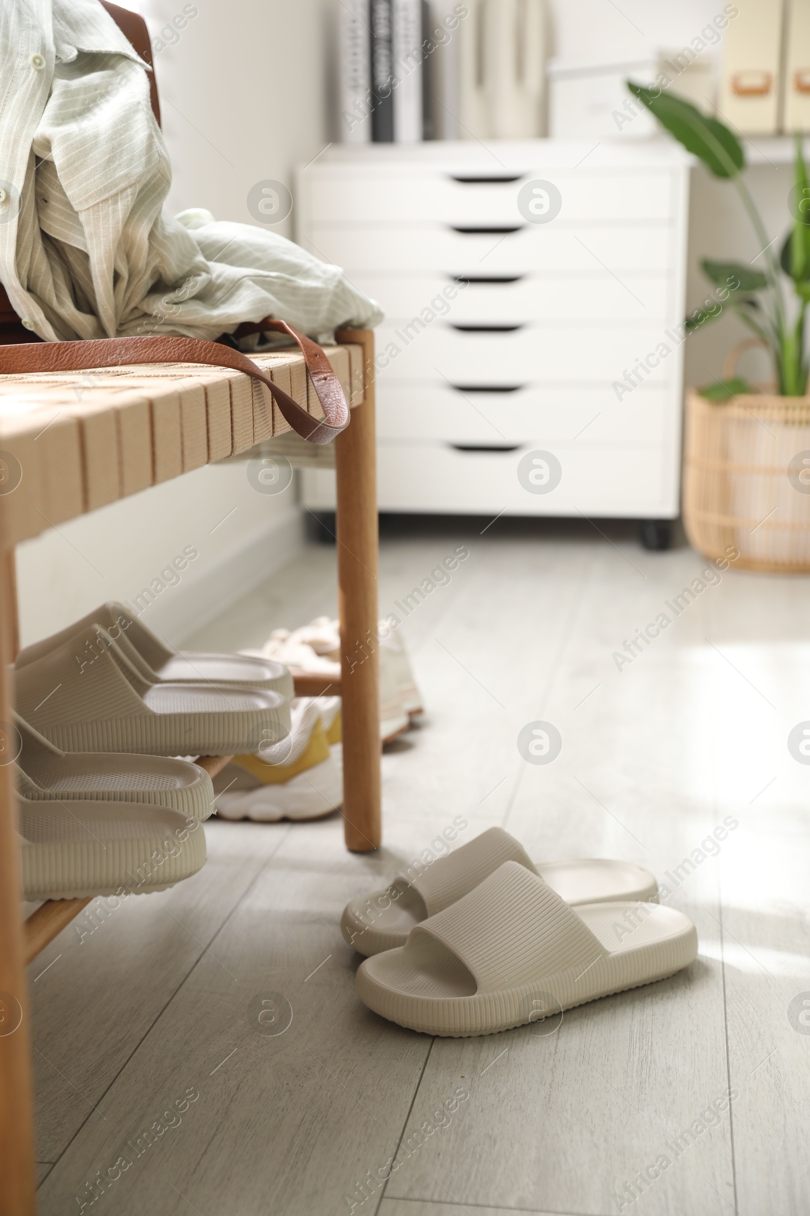 Photo of Many pairs of slippers and other shoes in entryway at home