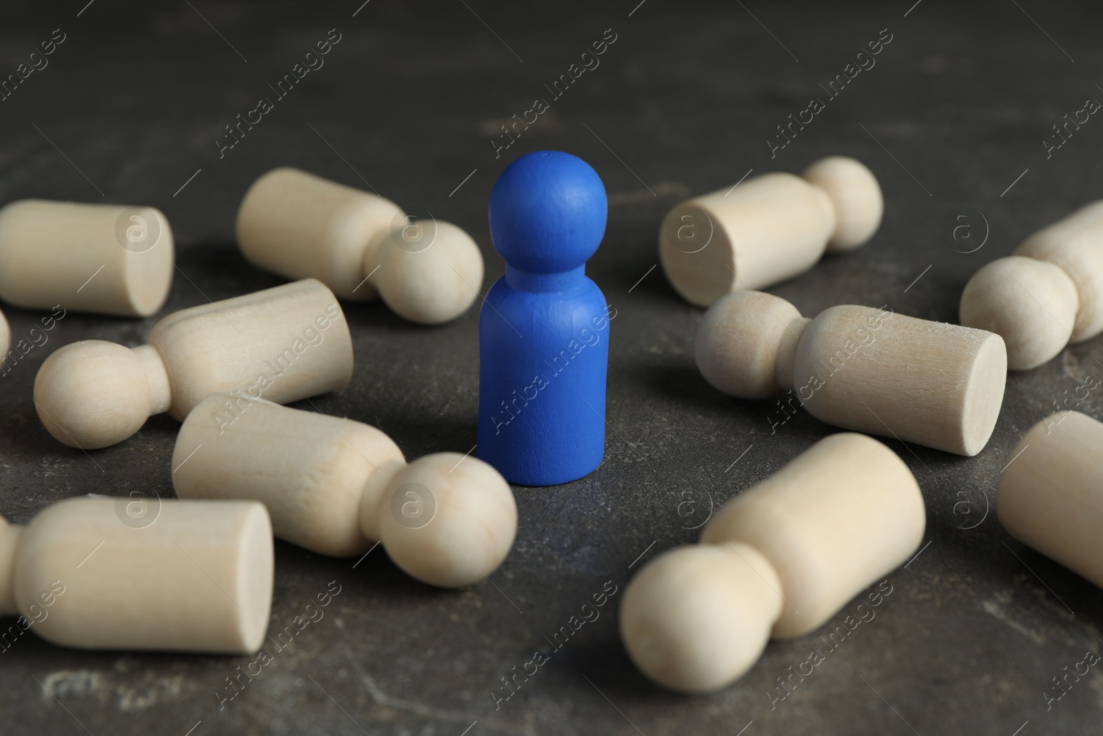 Photo of Blue piece among wooden ones on grey table, closeup