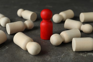 Photo of Red piece among wooden ones on grey table, closeup