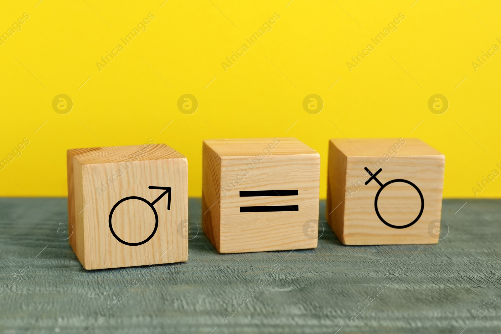 Image of Cube with equals sign between female and male gender symbols on yellow background