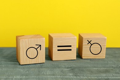 Image of Cube with equals sign between female and male gender symbols on yellow background