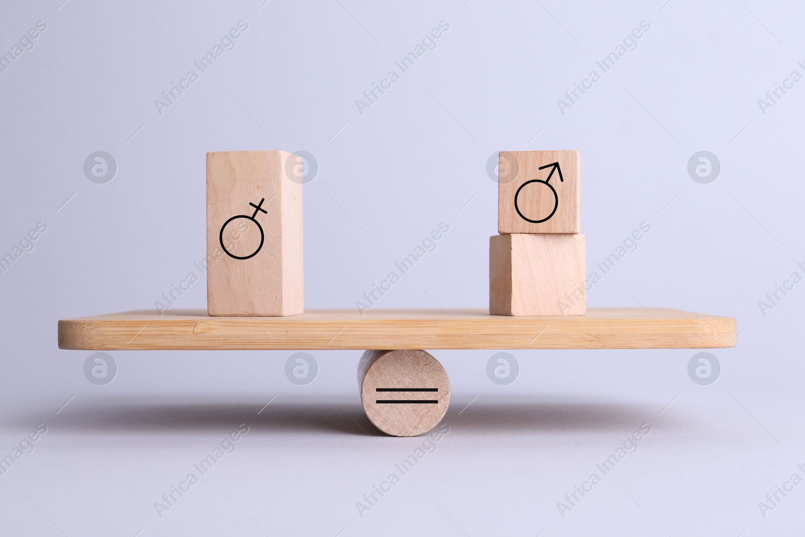 Image of Wooden balance scales with cubes showing concept of equality between men and women