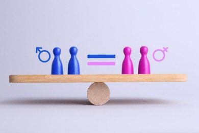 Image of Wooden balance scales with pawns showing concept of equality between men and women