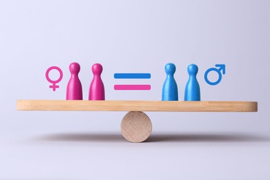 Image of Wooden balance scales with pawns showing concept of equality between men and women