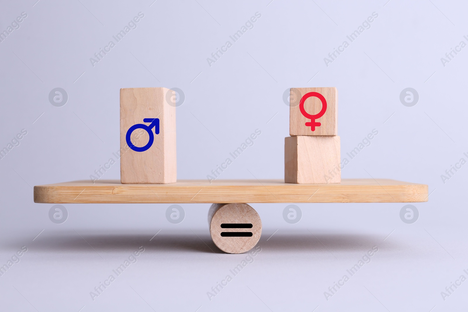 Image of Wooden balance scales with cubes showing concept of equality between men and women