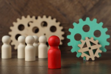 Photo of Red piece among wooden ones and gear set on table